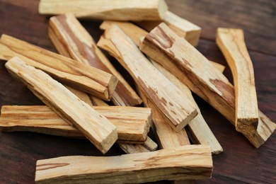 Photo of Many palo santo sticks on wooden table, closeup