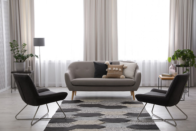 Photo of Modern living room interior with comfortable sofa and armchairs