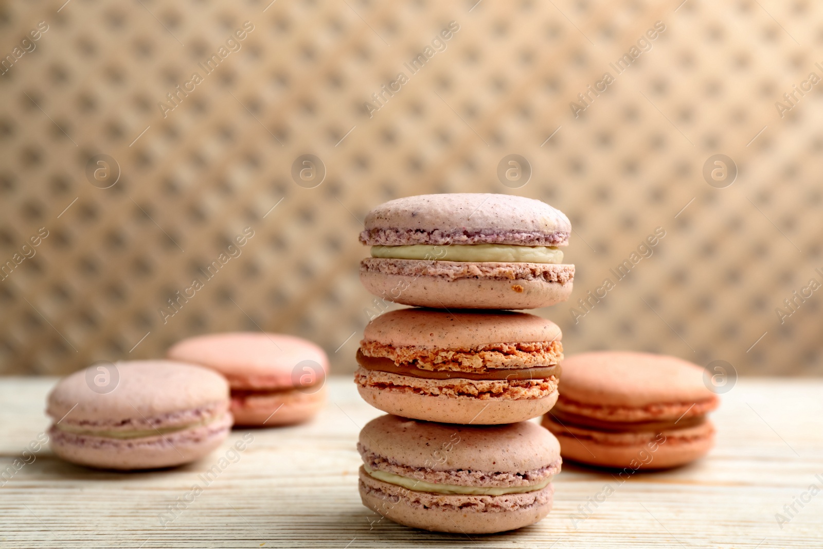 Photo of Delicious macarons on white wooden table. Sweet dessert