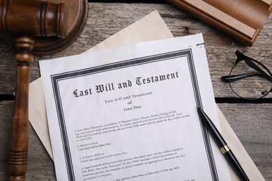 Photo of Last will and testament near glasses with gavel on wooden table, flat lay