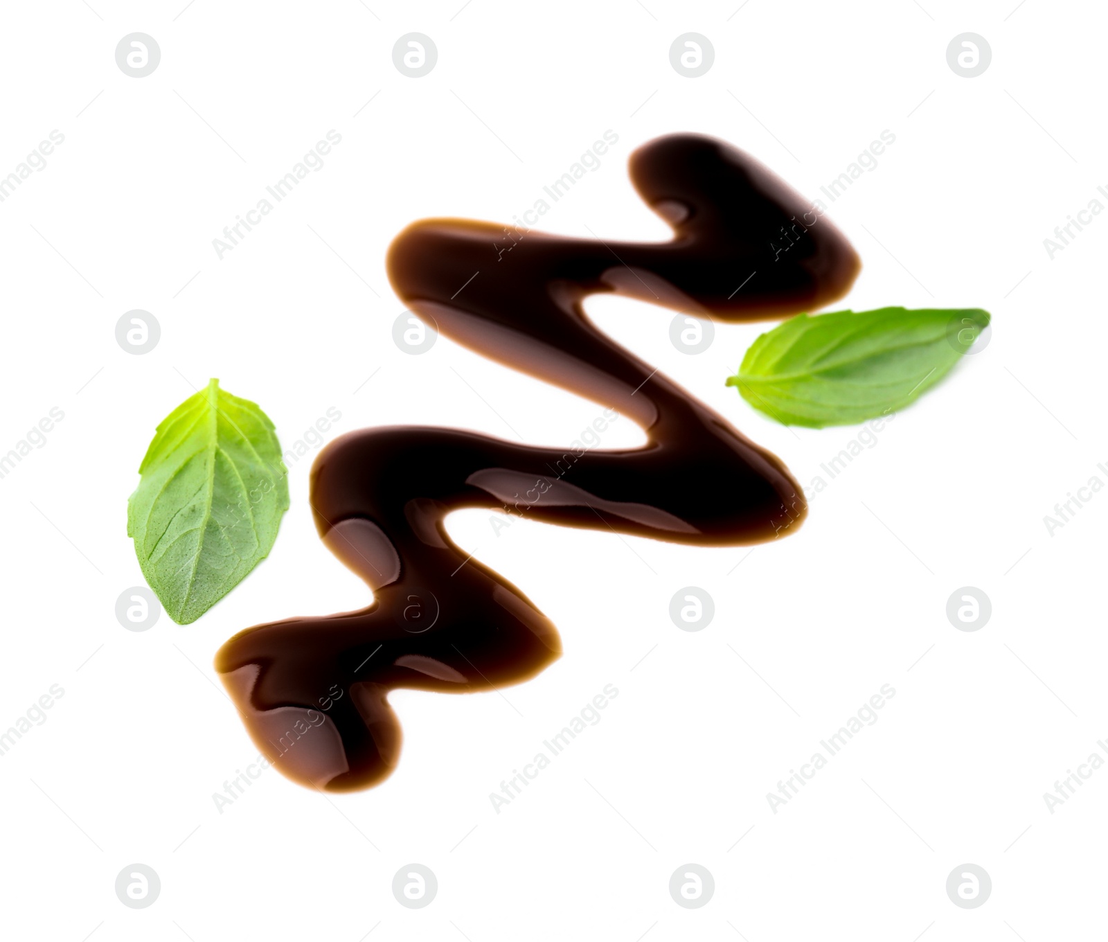 Photo of Balsamic glaze and basil leaves on white background