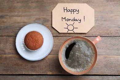 Photo of Happy Monday message, aromatic coffee and cupcake on wooden table, flat lay