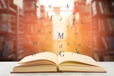 Image of Open book with letters flying out of it in library