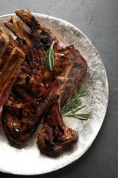 Photo of Delicious grilled ribs served on black table, top view
