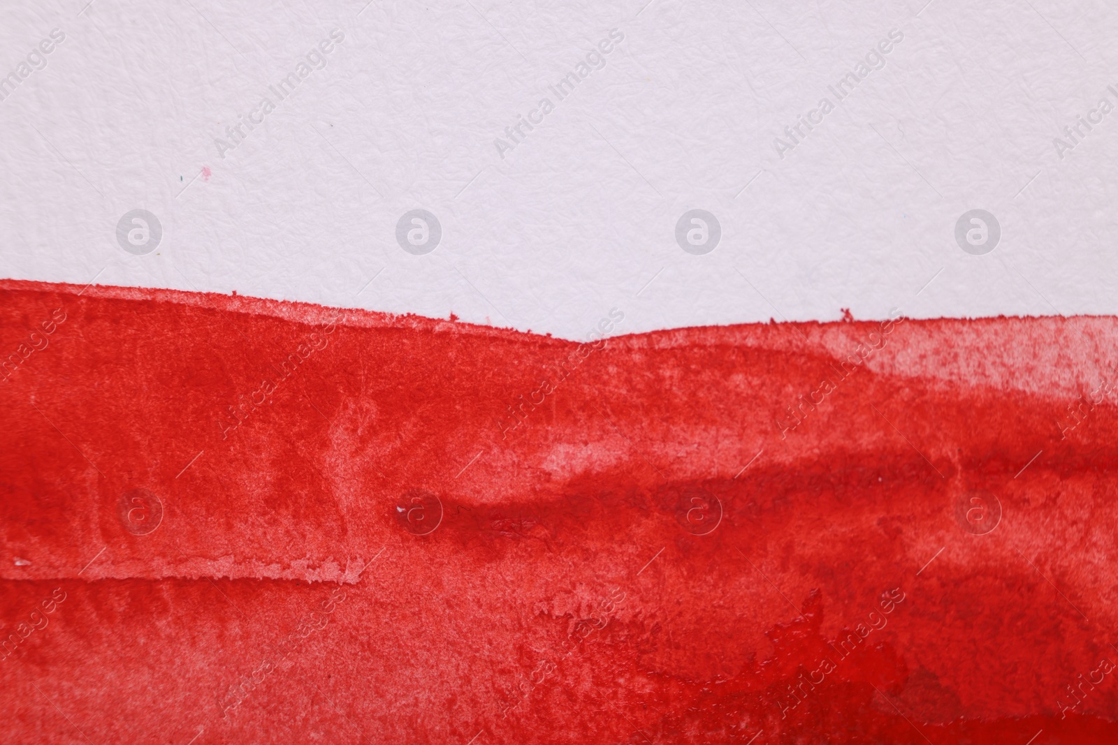 Photo of Abstract red watercolor painting on white paper, top view