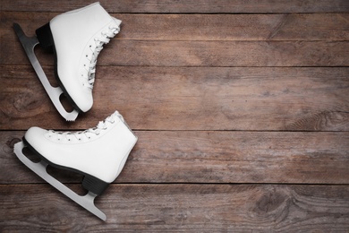 Photo of Pair of skates on wooden background, flat lay. Space for text