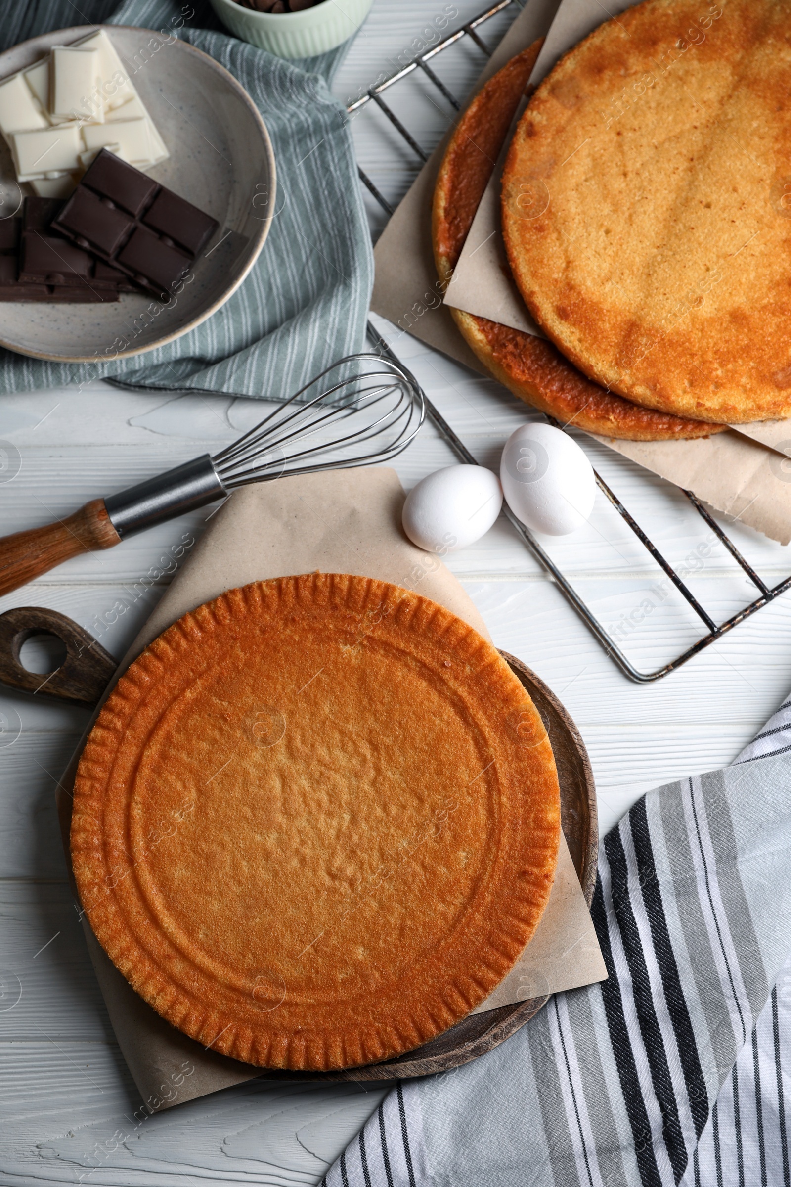 Photo of Ingredients for delicious homemade layer cake preparing on white wooden table, flat lay