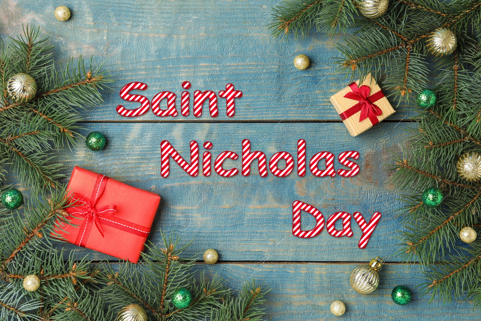 Image of Saint Nicholas Day. Flat lay composition with fir branches and gifts on blue wooden background