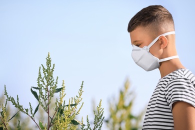 Photo of Little boy suffering from ragweed allergy outdoors