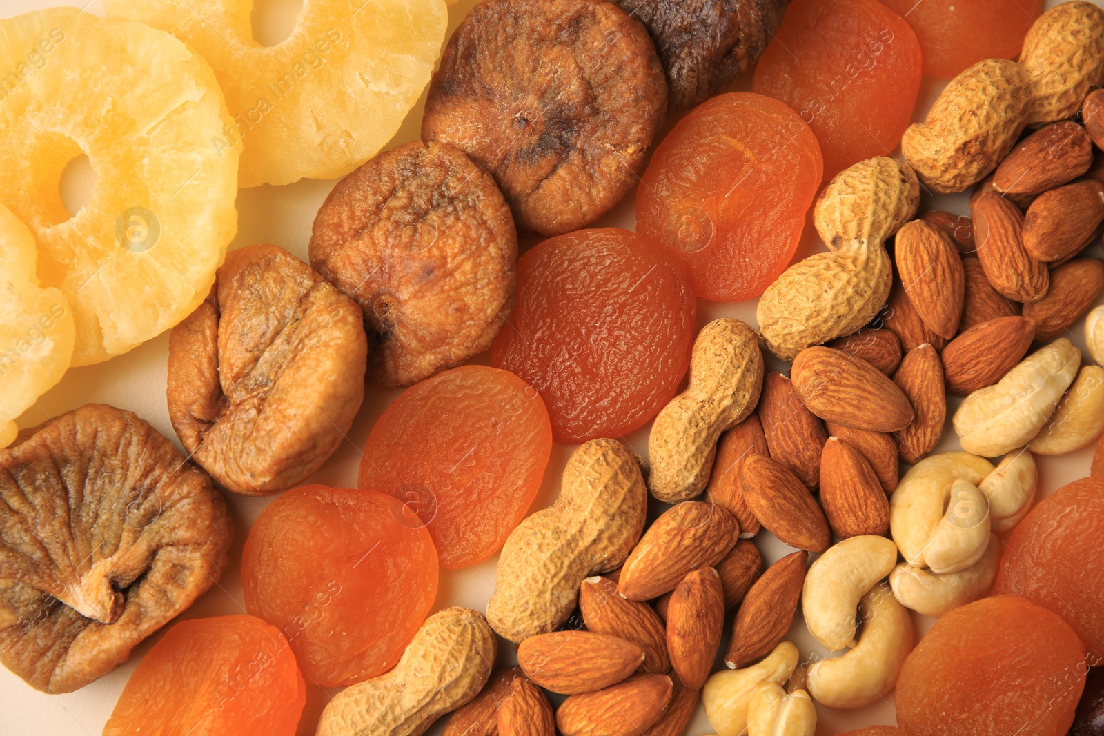 Photo of Different tasty nuts and dried fruits as background, top view