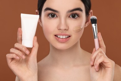 Photo of Teenage girl with tube of foundation and brush on brown background