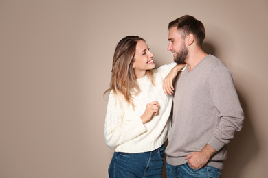 Image of Lovely couple in warm sweaters on beige background