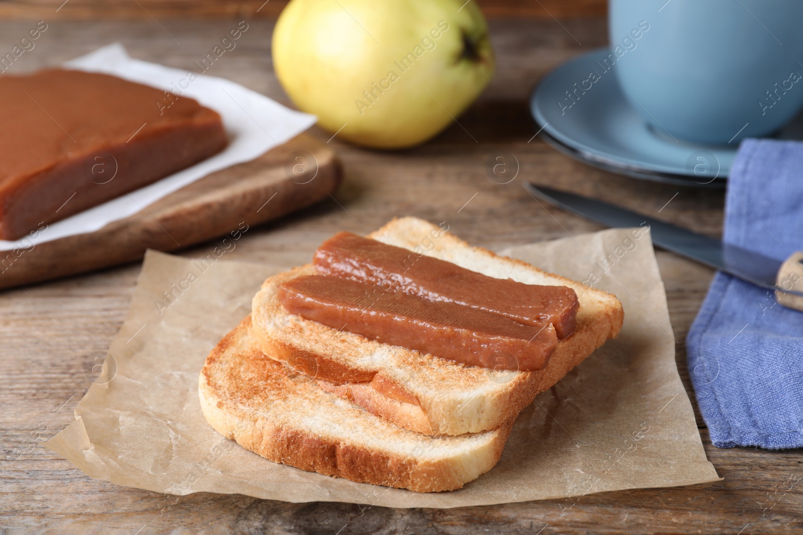 Photo of Tasty sandwich with quince paste served for breakfast on wooden table