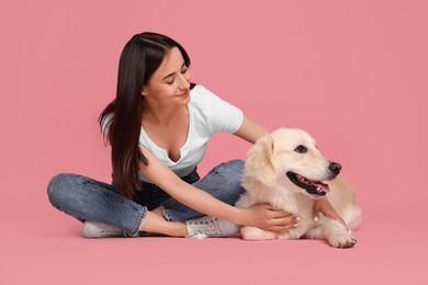 Photo of Happy woman with cute Labrador Retriever dog on pink background. Adorable pet