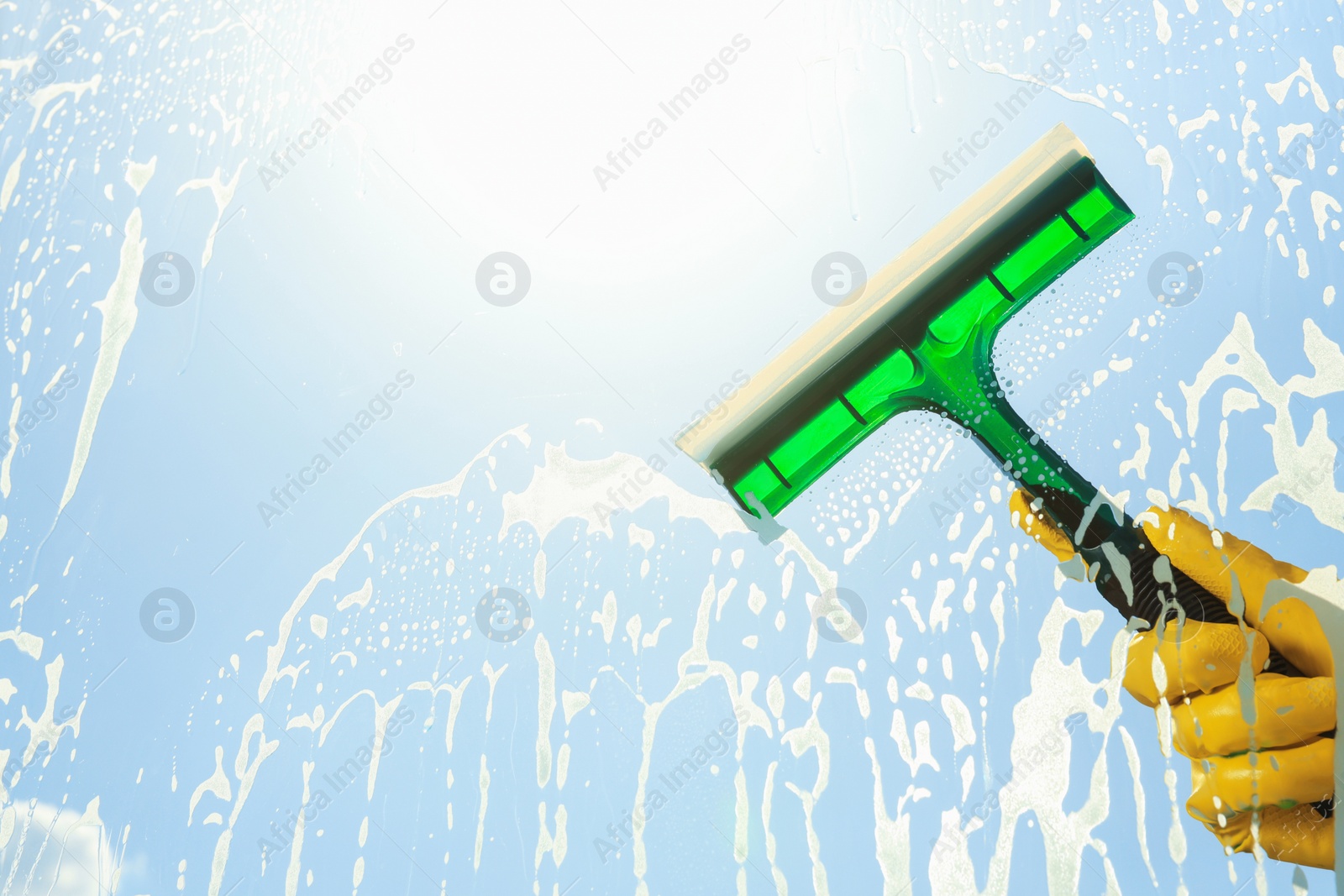 Photo of Person cleaning glass with squeegee , view from inside