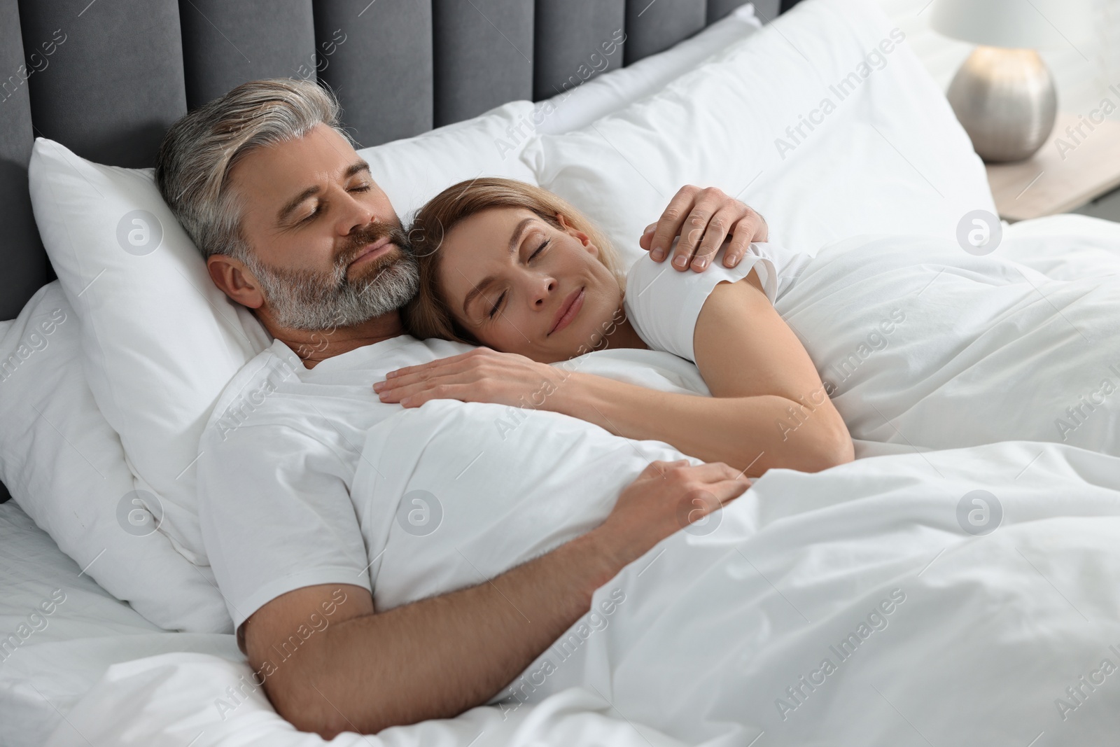 Photo of Lovely mature couple sleeping together in bed at home