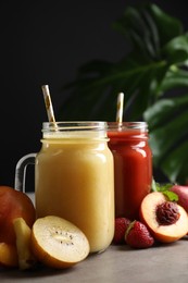 Delicious juices and fresh ingredients on grey table