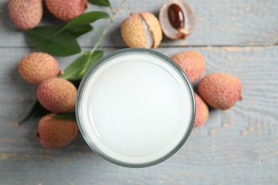 Photo of Fresh lychee juice and fruits on grey wooden table, flat lay