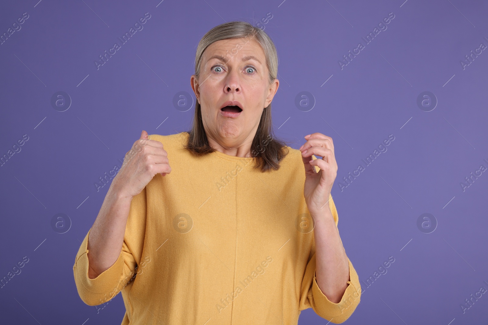 Photo of Portrait of surprised senior woman on violet background