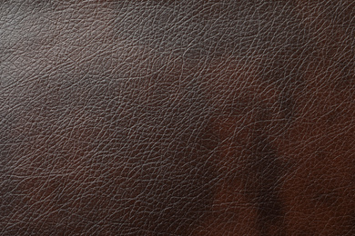 Texture of dark brown leather as background, closeup