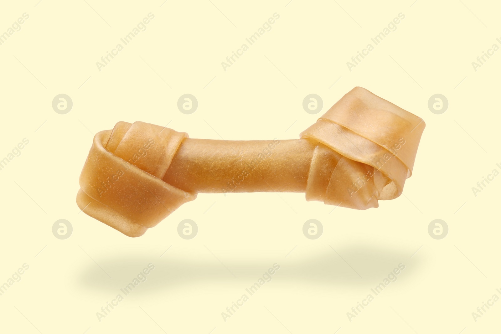 Image of Bone dog treat in air on beige background