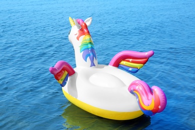 Photo of Funny inflatable unicorn ring floating on sea water. Summer vacation