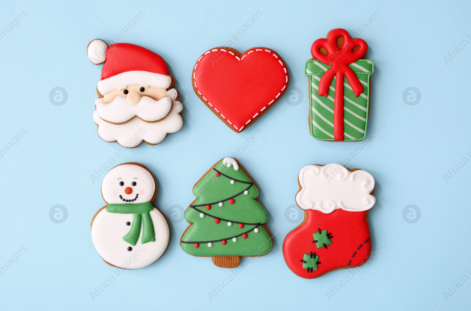 Photo of Different Christmas gingerbread cookies on light blue background, flat lay