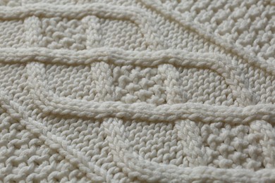 Photo of White knitted fabric with beautiful pattern as background, closeup