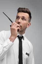 Photo of Male security guard using portable radio transmitter on color background