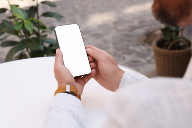 Photo of Man using smartphone at white table outdoors, closeup