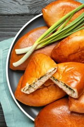 Photo of Many delicious baked patties with eggs and herbs on black wooden table, top view