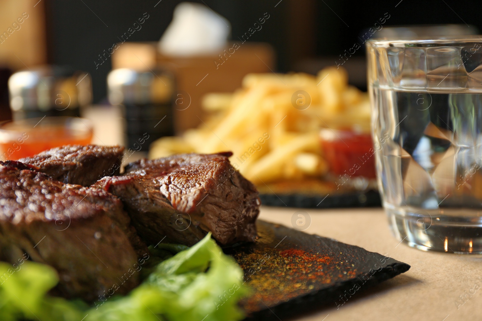 Photo of Tasty pieces of shish kebab served on slate plate in cafe