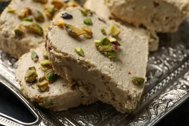 Photo of Tray with tasty pistachio halva on table, closeup