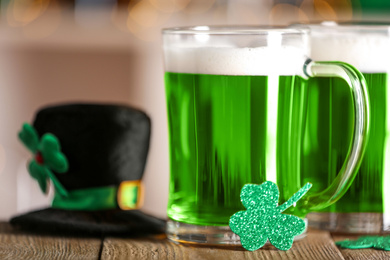 Photo of Green beer and clover on wooden counter, closeup. St.Patrick's Day