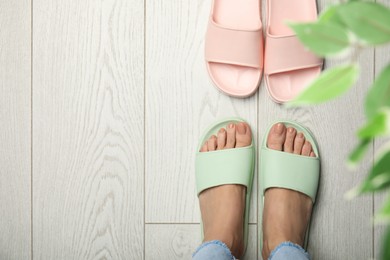 Photo of Woman wearing comfortable rubber slippers indoors, top view. Space for text