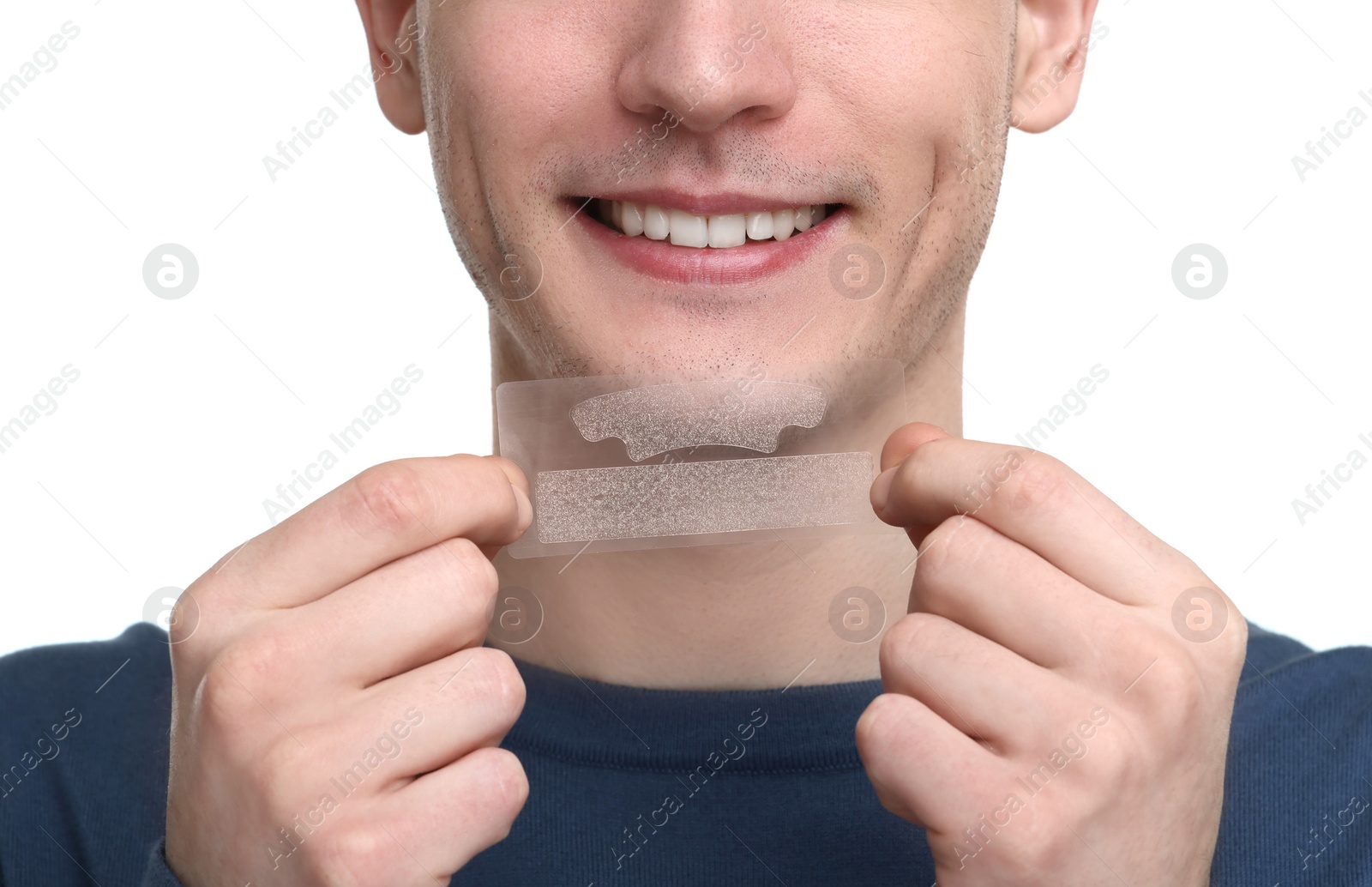 Photo of Young man with whitening strips on light background, closeup