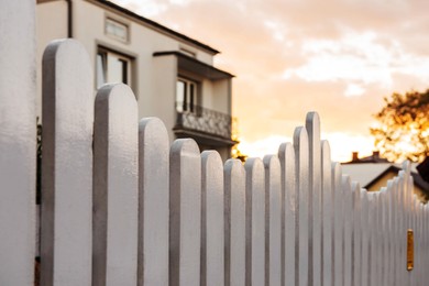 Photo of Houses behind beautiful white wooden fence outdoors