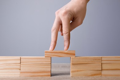 Photo of Woman crossing bridge with her fingers at table, closeup. Connection, relationships and deal concept