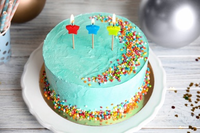 Fresh delicious birthday cake with candles on wooden table