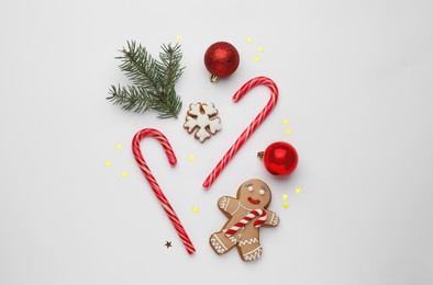 Flat lay composition with sweet candy canes and Christmas decor on white background