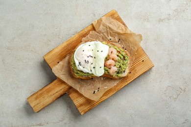 Photo of Delicious sandwich with guacamole, shrimps and fried egg on light grey table, top view