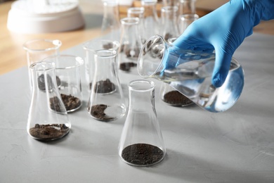 Scientist preparing soil extract at table, closeup. Laboratory research