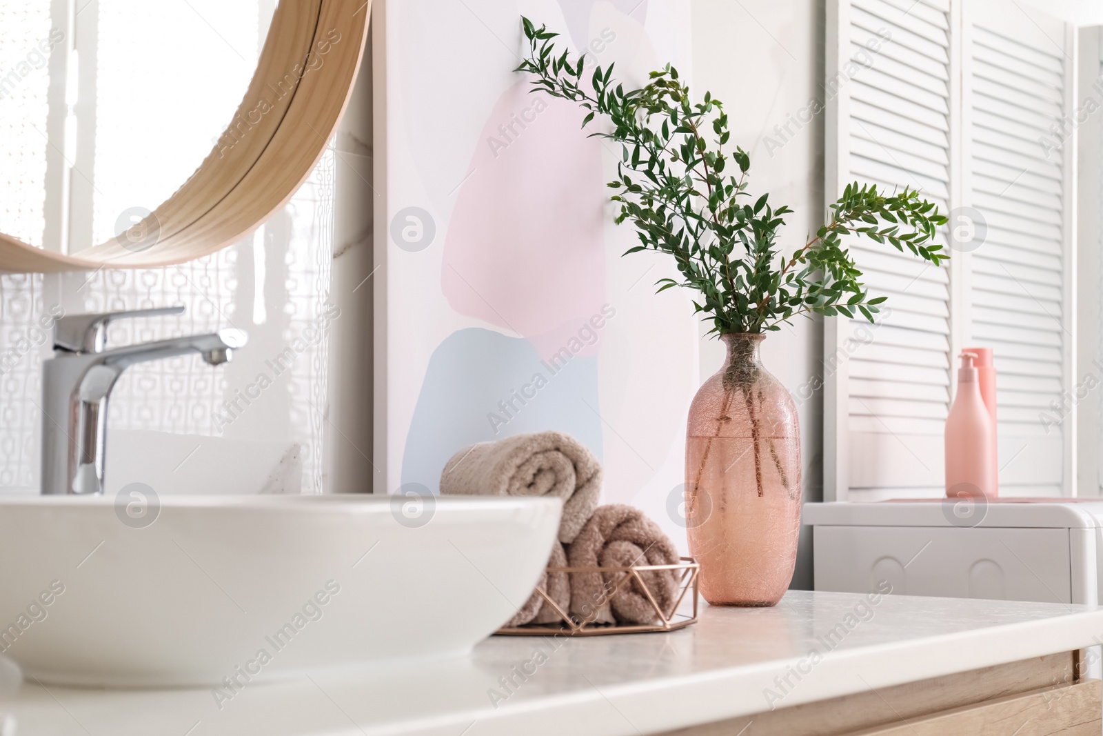 Photo of Vase with beautiful branches and fresh towels near vessel sink in bathroom. Interior design