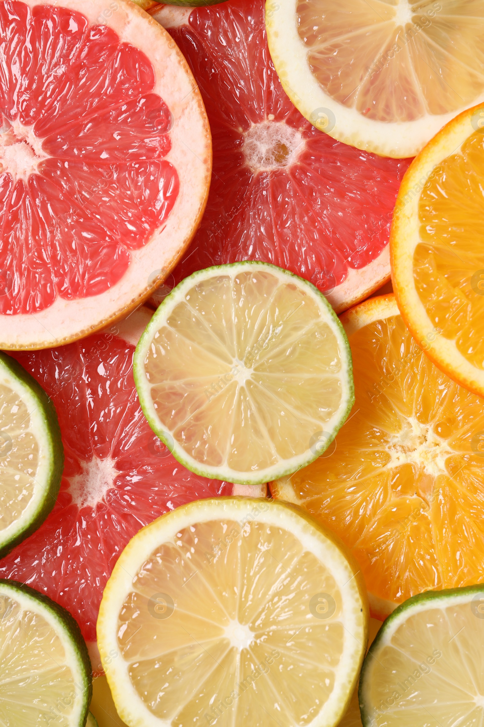 Photo of Different sliced citrus fruits as background, top view