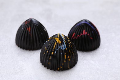 Tasty chocolate candies on light grey table