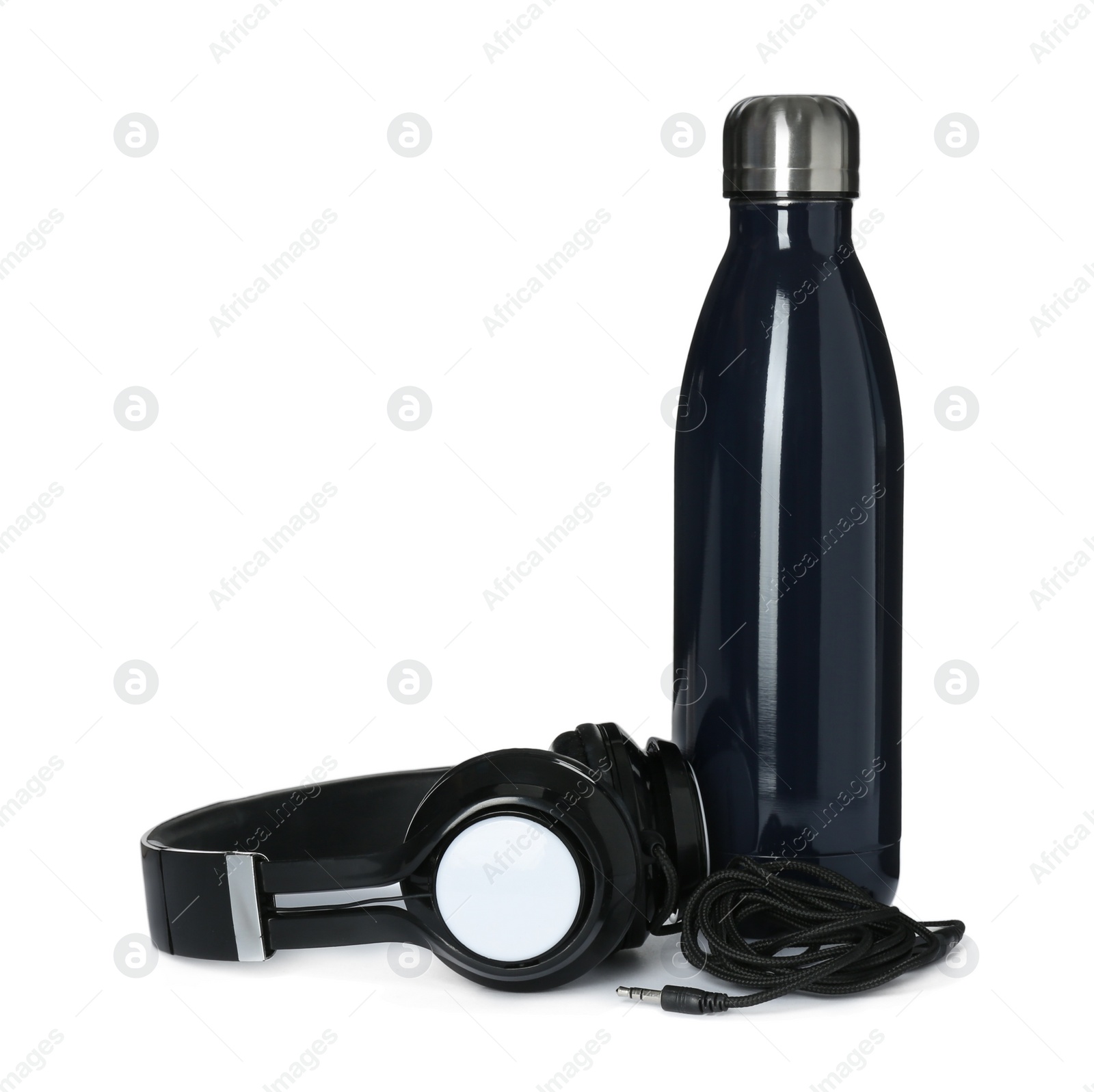 Photo of Modern thermo bottle and headphones on white background