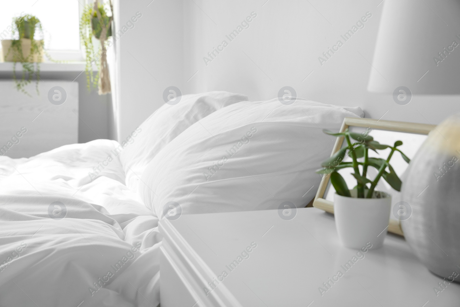 Photo of Large comfortable bed with soft pillows and blanket indoors