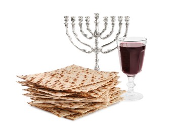 Photo of Traditional matzos, red wine and menorah on white background