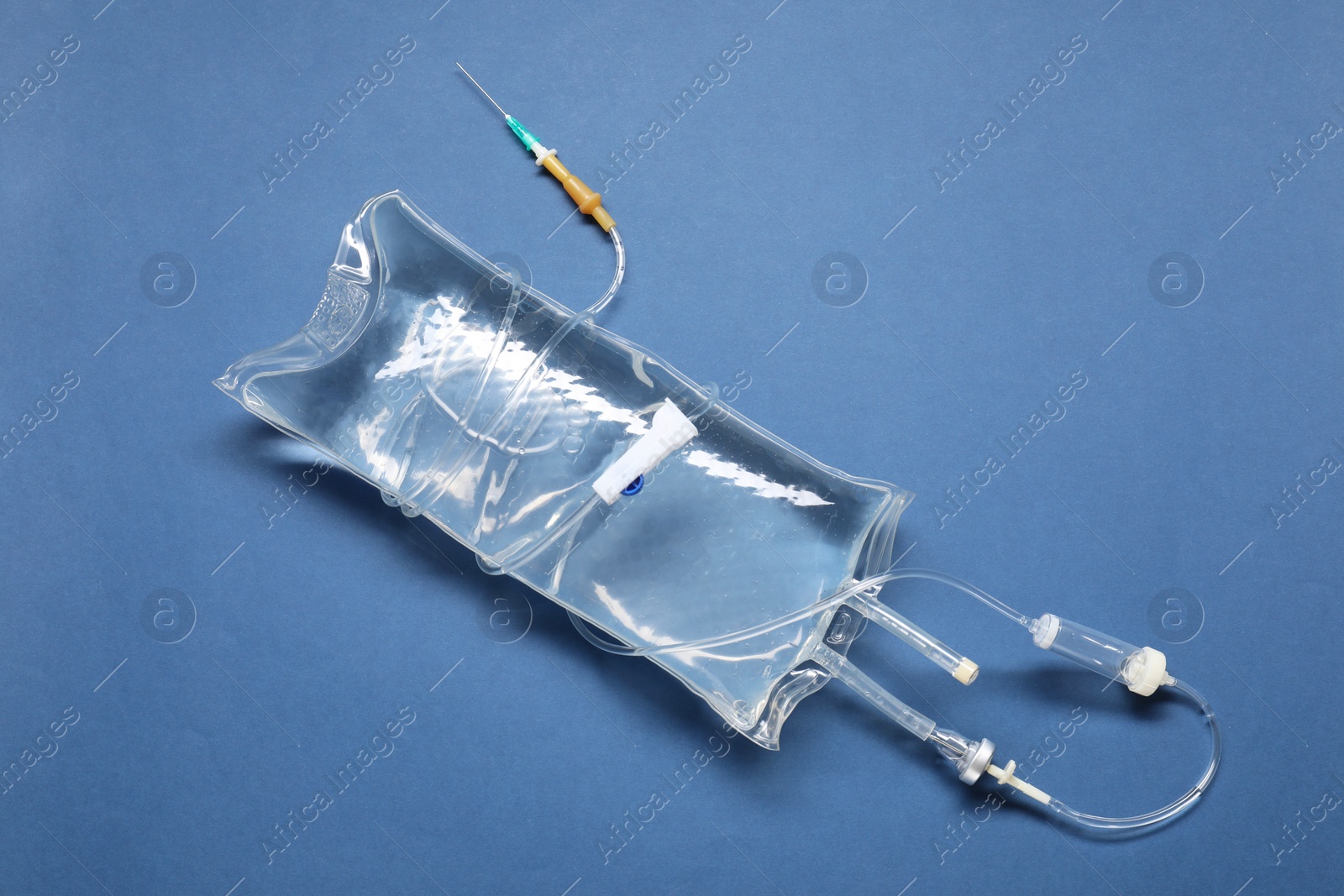 Photo of IV infusion set on blue background, top view