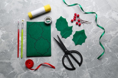 Set of instruments and materials for making mistletoe branch on grey table, flat lay